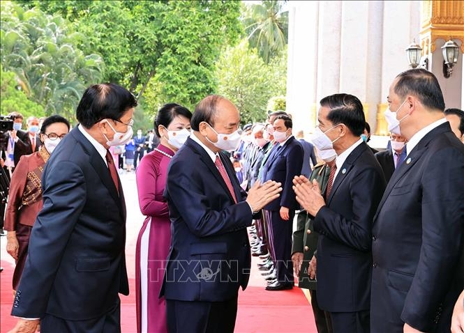 Chủ tịch nước CHXHCN Việt Nam Nguyễn Xuân Phúc và Tổng Bí thư, Chủ tịch nước Lào Thongloun Sisoulith với các thành viên đoàn đại biểu cấp cao hai nước tại lễ đón. Ảnh: Thống Nhất/TTXVN