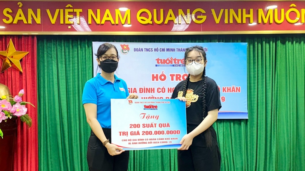 Em Nguyễn Thùy Linh, học sinh lớp IG2A, Trường Singapore International School, Hà Nội đại diện các nhà tài trợ trao hỗ trợ cho 200 hộ gia đình có hoàn cảnh khó khăn trên địa bàn quận Hoàng Mai.