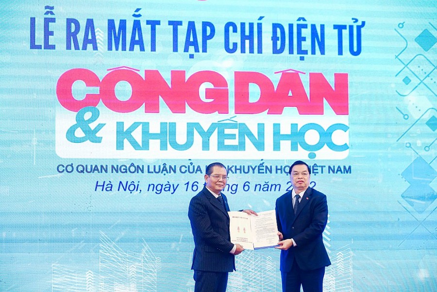 Phó Chủ tịch Hội Khuyến học Việt Nam Lê Mạnh Hùng trao quyết định và tặng hoa cho Tổng Biên tập Tô Quang Phán