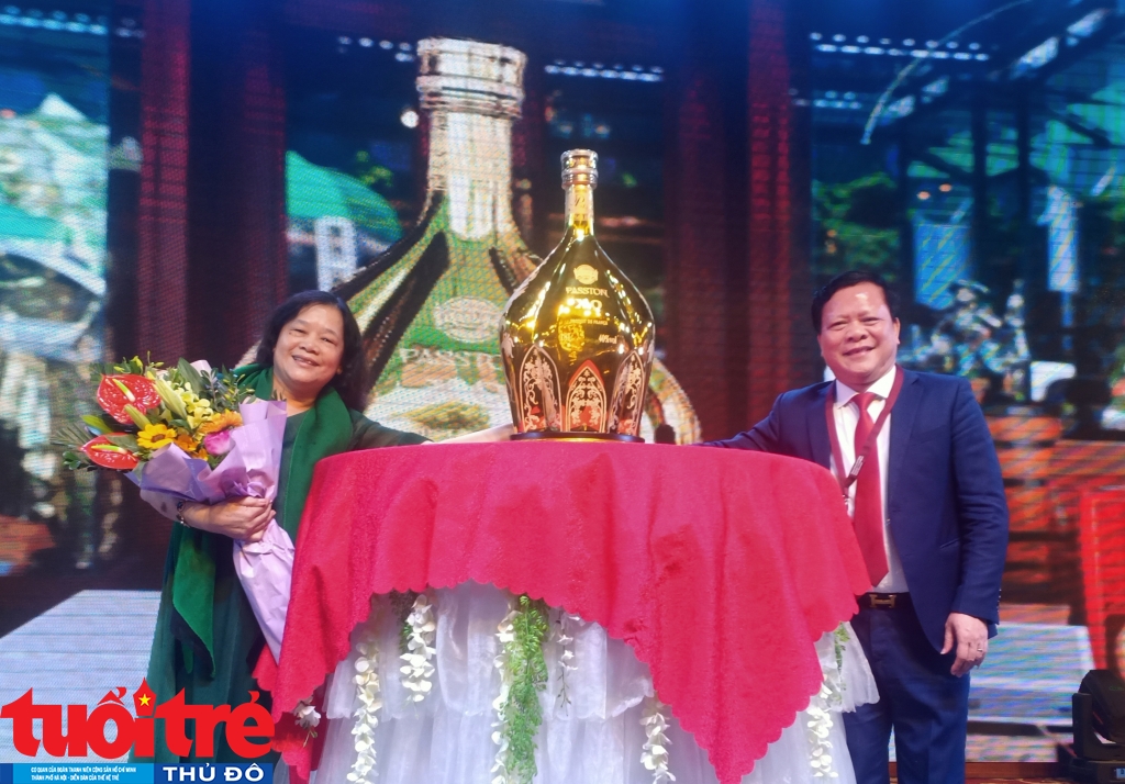 Ông Mai Xuân Thắng - Chủ tịch HĐQT Hải Đăng Plaza trao chai rượu XO 18 lít cho bà Trần Thị Minh Thuý, trúng đấu giá 57 triệu đồng