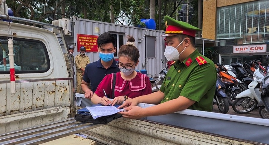 Người dân ký biên bản sau khi được tuyên truyền, nhắc nhở vi phạm