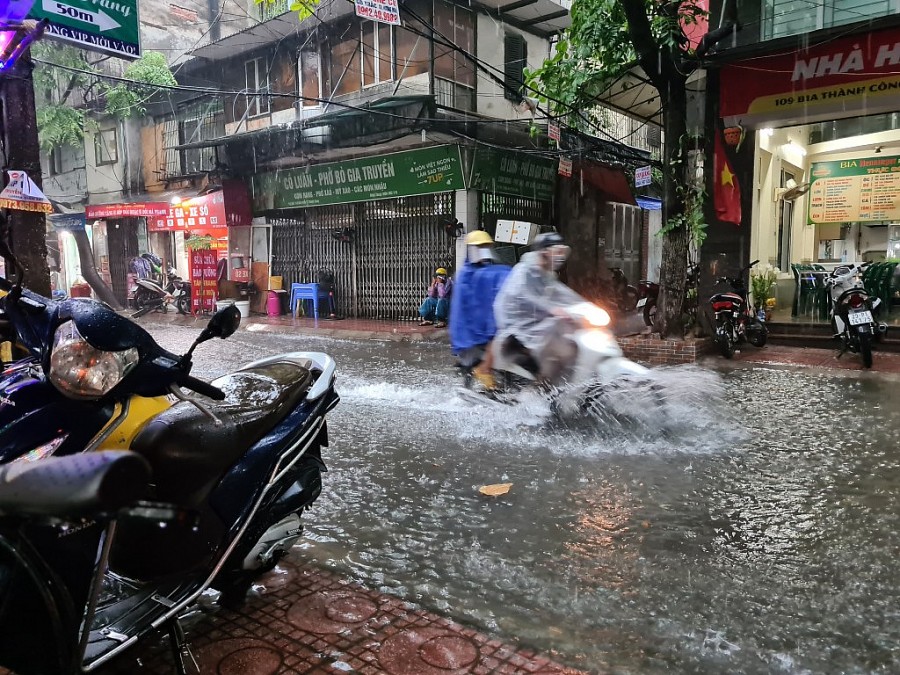 Người dân di chuyển trong thời tiết mưa to trên ngõ Nguyên Hồng