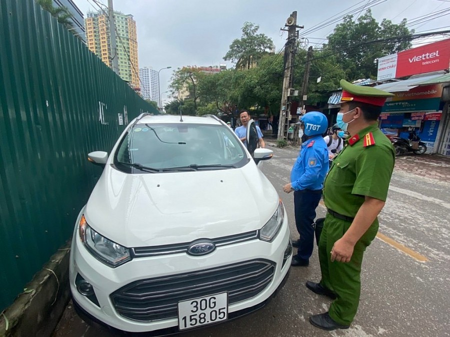 Lực lượng chức năng yêu cầu chủ phương tiện di chuyển khỏi khu vực hàng rào tôn quanh bãi xe tự động đường Nguyên Hồng