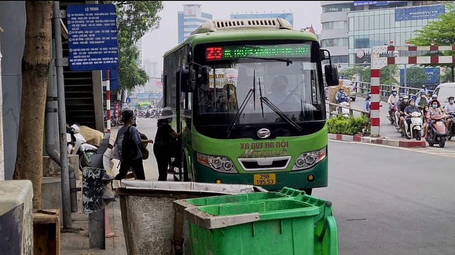 Người dân đi xe buýt chỉ muốn nhanh chóng lên xe để tránh mùi xú uế từ các loại rác thải ở khu vực điểm dừng này