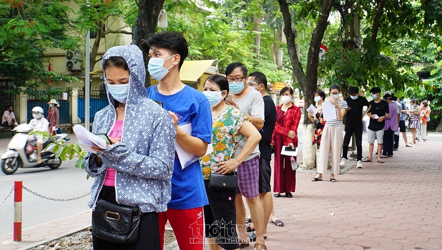 Người dân xếp hàng đảm bảo giãn cách ngay từ ngoài cổng địa điểm tổ chức tiêm