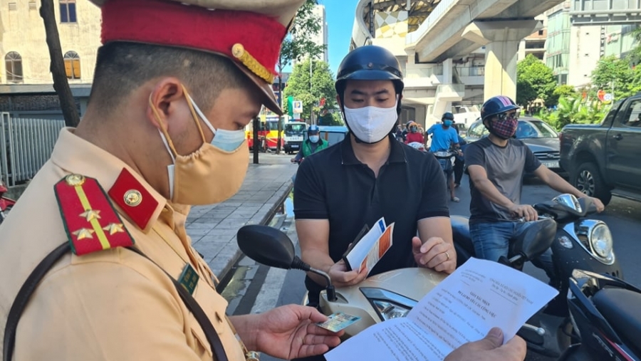 Thành viên tổ kiểm soát cơ động kiểm tra giấy tờ người đi đường trên đường Nguyễn Trãi