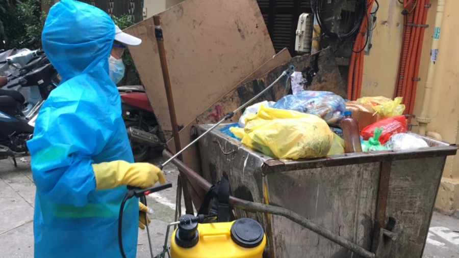 Công việc buộc những công nhân vệ sinh môi trường gắn với bộ quần áo bảo hộ màu xanh