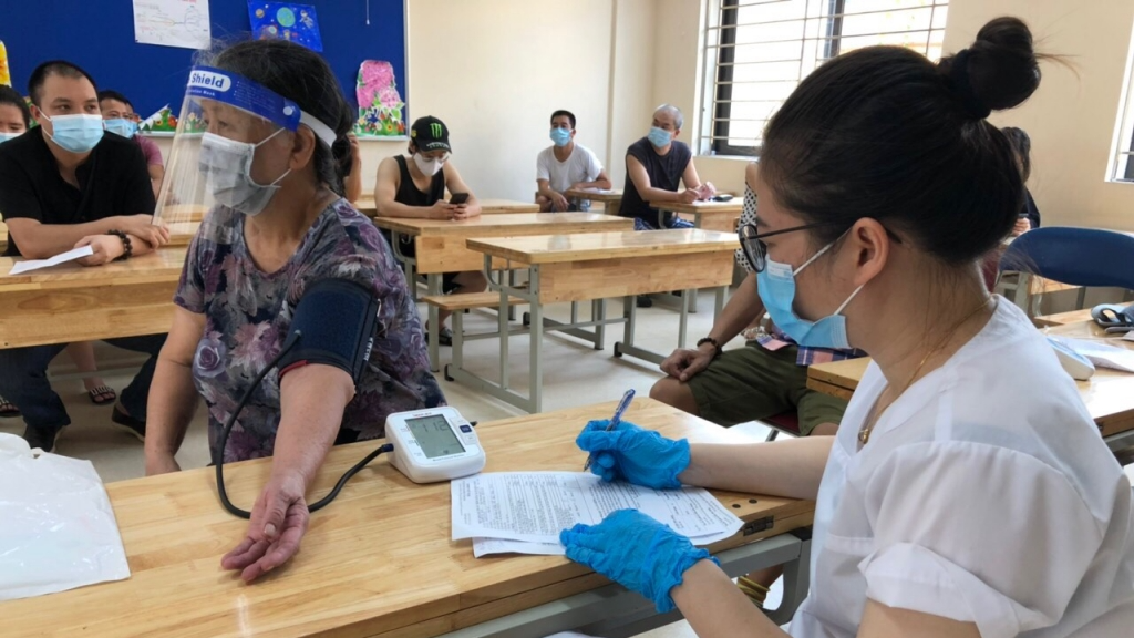 Người dân Ba Đình được đo huyết áp trước khi tiêm vắc xin