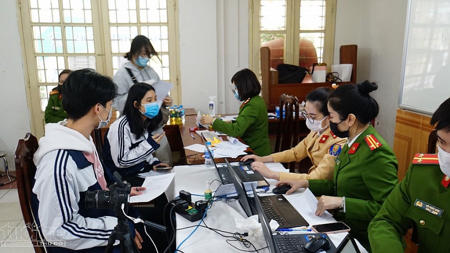 Các cán bộ chiến sĩ Công an quận Hoàn Kiếm tích cực làm thủ tục cấp CCCD gắn chíp cho học sinh tại điểm tiêm chủng trường THPT Việt Đức