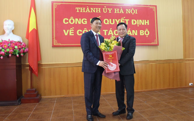 Phó Bí thư Thành ủy Hà Nội Nguyễn Văn Phong trao quyết định và tặng hoa chúc mừng đồng chí Đỗ Anh Tuấn