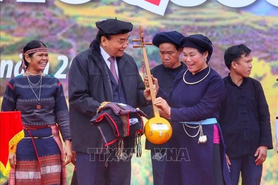 Đồng bào các dân tộc tại Làng tặng quà cho Chủ tịch nước Nguyễn Xuân Phúc. Ảnh: TTXVN