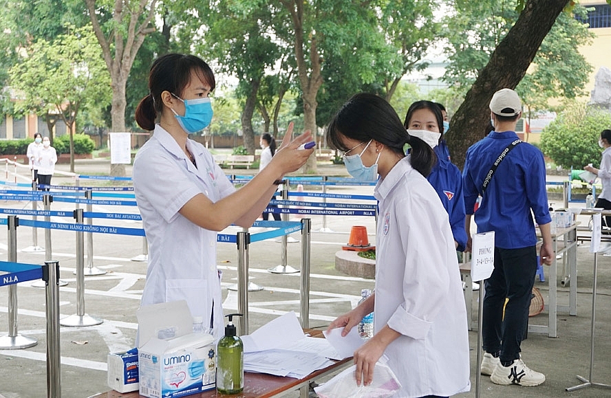 Thí sinh được đo thân nhiệt trước khi vào phòng thi tại điểm thi Trường Trung học phổ thông Sóc Sơn (huyện Sóc Sơn).