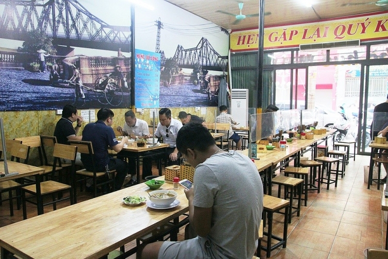 Một quán ăn ở Hà Nội lắp tấm chắn theo quy định về phòng chống dịch Covid-19.