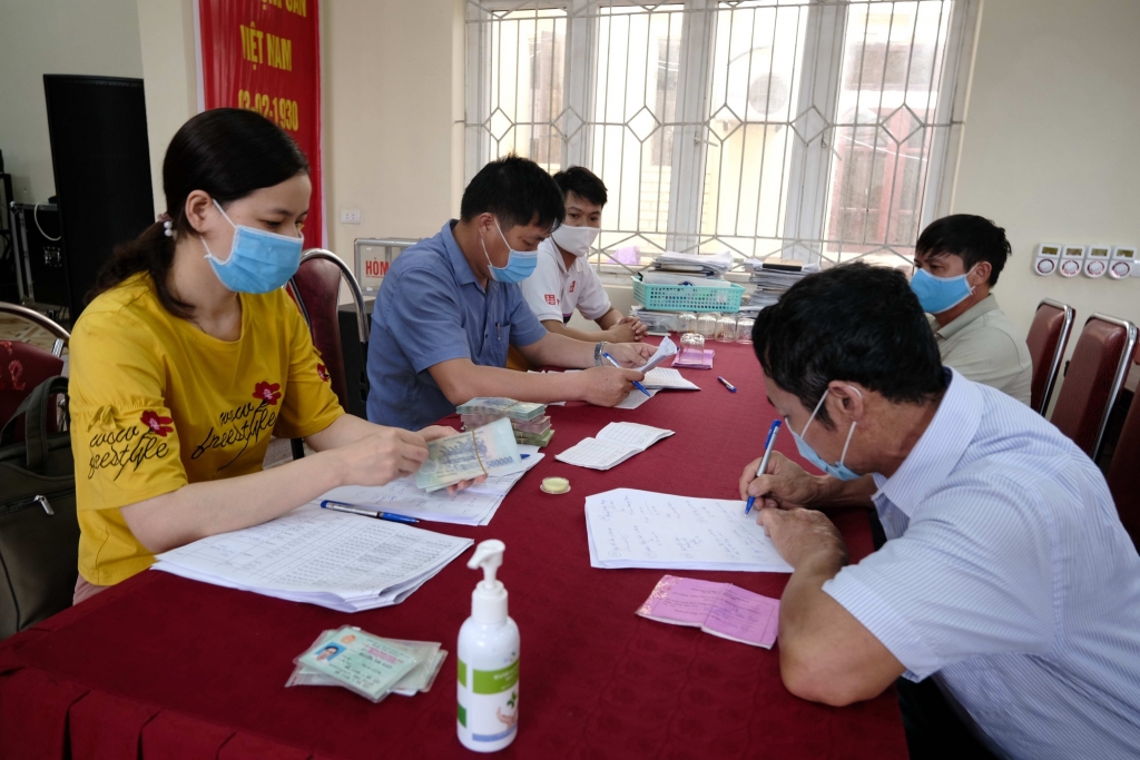 Người dân bị ảnh hưởng bởi dịch Covid-19 làm thủ tục nhận tiền hỗ trợ tại xã Đại Thịnh, H.Mê Linh, Hà Nội