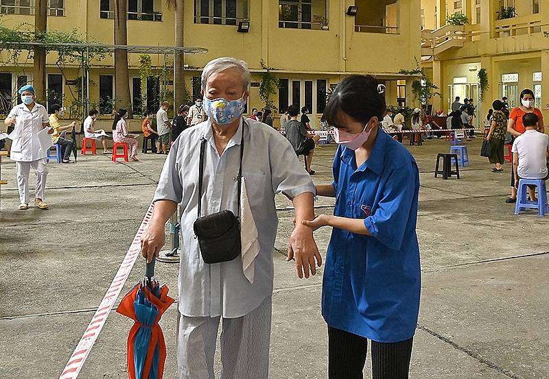 Thanh niên tình nguyện hỗ trợ người cao tuổi sau tiêm