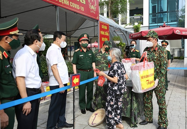 Lãnh đạo Bộ Tư lệnh Thủ đô và quận Đống Đa trao quà cho người dân gặp khó khăn.  