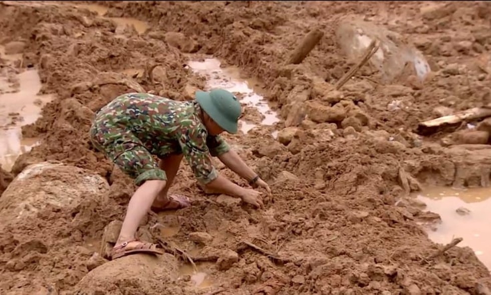 Một chiến sĩ công binh vốc từng vốc bùn để không làm ảnh hưởng đến thi thể các nạn nhân