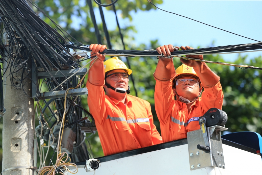 Công nhân sửa chữa điện trong trang phục mới đang thực hiện công tác trên xe nâng người làm việc trên cao