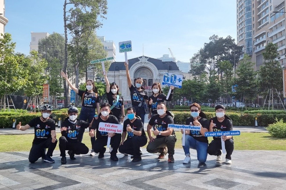 Phó bí thư thường trực Đảng ủy TCT Điện lực TPHCM Bùi Hải Thành (thứ 2 bên trái) cùng các tình nguyện viên giơ cao các thông điệp của Chiến dịch Giờ Trái đất năm 2022 tại TPHCM (ảnh Chi Lan).