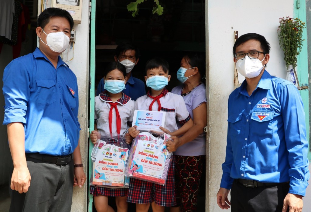 Đồng chí Huỳnh Tấn Khương, Bí thư Đoàn Thanh niên EVNHCMC (bên phải) tặng máy tính bảng cho thiếu nhi khó khăn, mất người thân do COVID-19 tại huyện Nhà Bè