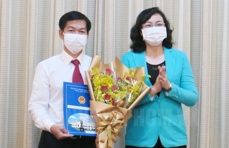 Phó Chủ tịch UBND TP HCM Phan Thị Thắng trao quyết định và tặng hoa chúc mừng ông Đào Minh Chánh, Phó Giám đốc Sở Kế hoạch và Đầu tư TP HCM