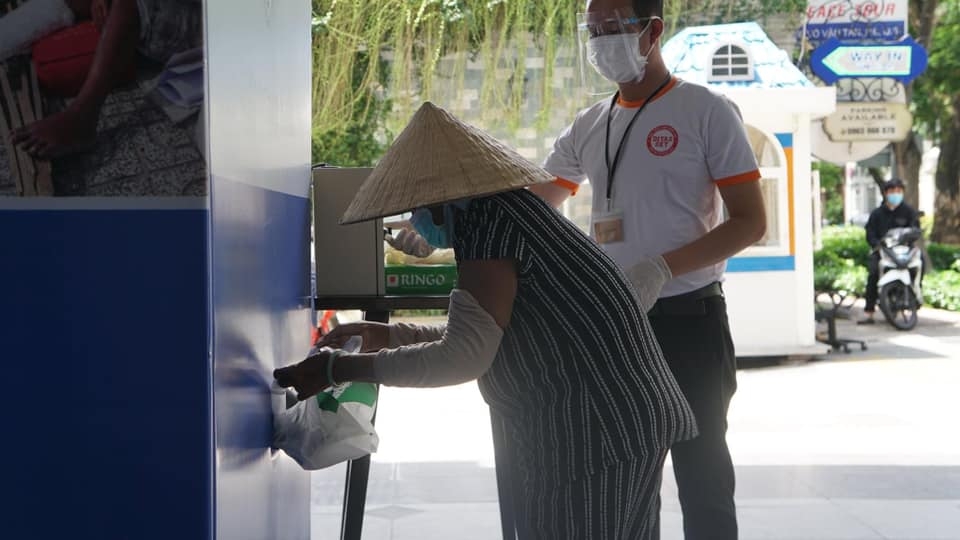 Cán bộ, nhân viên tập đoàn C.T Group hướng dẫn bà con nhận gạo từ ATM gạo miễn phí