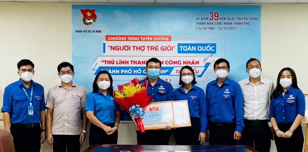 Phó Bí thư thường trực Đảng ủy EVNHCMC Bùi Hải Thành (bìa trái) và Phó Bí thư Thành đoàn TP.HCM Trần Thu Hà (bìa phải) trao giải thưởng cho bạn Đoàn Ngọc Minh