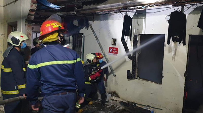 Lực lượng chức năng phun nước làm mát hiện trường vụ cháy, nổ tại ngôi nhà trọ ở phố Định Công Thượng 