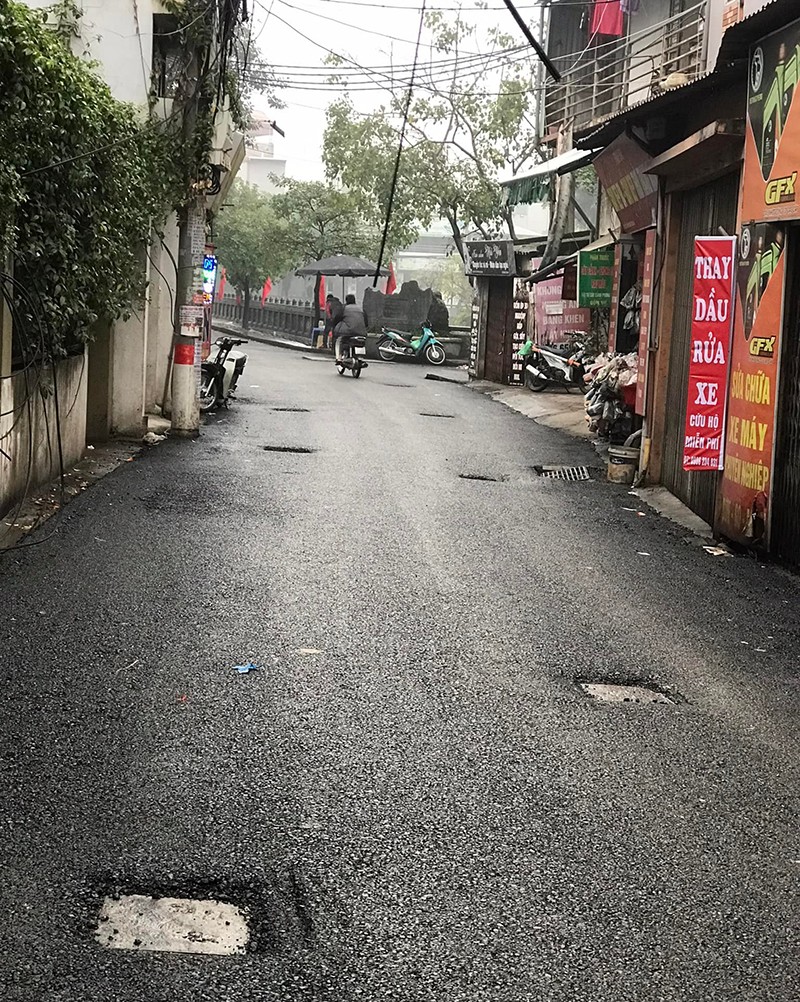 Hai hàng hố ga lõm xuống sau khi trải thảm nhựa áp phan tôn đường phố Định Công Hạ