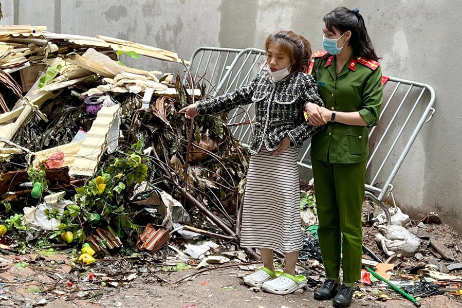 Cảnh sát áp giải người phụ nữ đi thực nghiệm hiện trường sau vụ phóng hoả, đốt nhà trọ ở phường Phú Đô