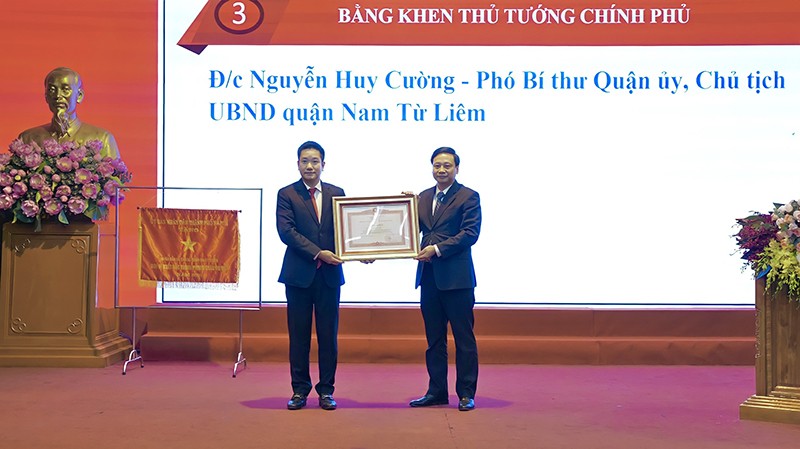 đồng chí Phạm Đức Toàn - Phó Trưởng Ban Thi đua - Khen thưởng Trung ương trao Bằng khen của Thủ tướng cho đồng chí Nguyễn Huy Cường – Phó Bí thư Quận uỷ, Chủ tịch UBND quận Nam Từ Liêm