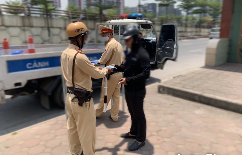 Lực lượng Cảnh sát giao thông Hà Nội tuyên truyền, phát khẩu trang miễn phí, đồng thời xử lý nghiêm người tham gia giao thông không đeo khẩu trang nơi công cộng