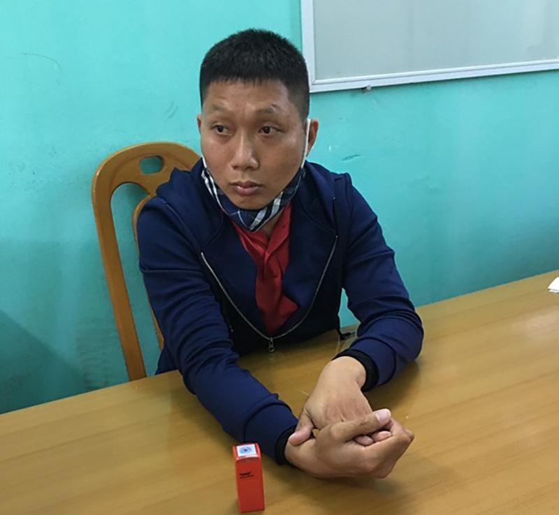 Đối tượng Lê Văn Mạnh cùng con dấu tang vật dùng để làm giấy giờ giả đưa người qua chốt kiểm soát dịch Covid-19