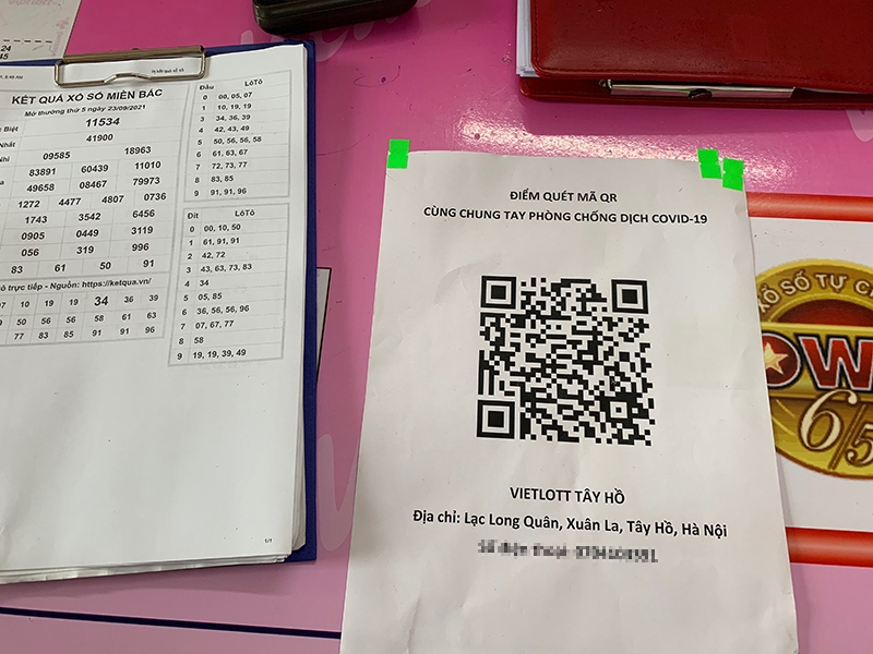 Mã quét QR Code được chủ cửa hàng sổ số bên cạnh dán trên quầy giao dịch