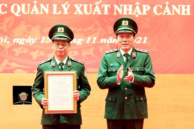 Thứ trưởng Bộ Công an Lương Tam Quang trao quyết định thành lập Phòng An ninh trên không cho thiếu tướng Quách Huy Hoàng, Cục trưởng Quản lý xuất nhập cảnh. Ảnh: TTXVN.