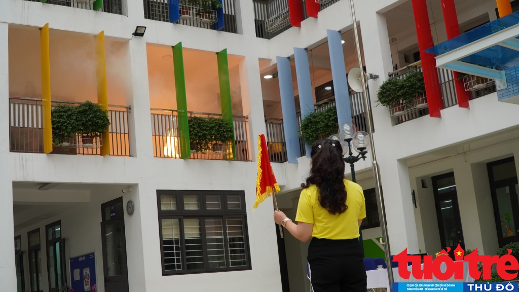 Cô Phạm Thị Thiên Nga - Hiệu trưởng nhà trường phất cờ hiệu, báo hiệu buổi diễn tập bắt đầu