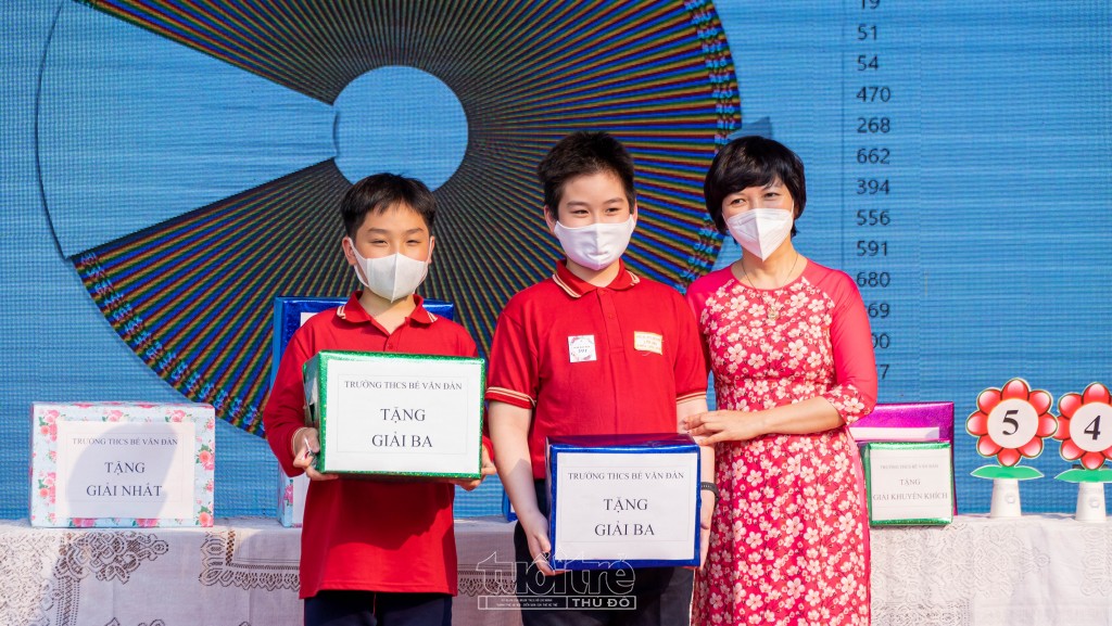 Cô Đào Thị Hồng Hạnh trao phần quà tới hai em học sinh may mắn trúng giải Ba