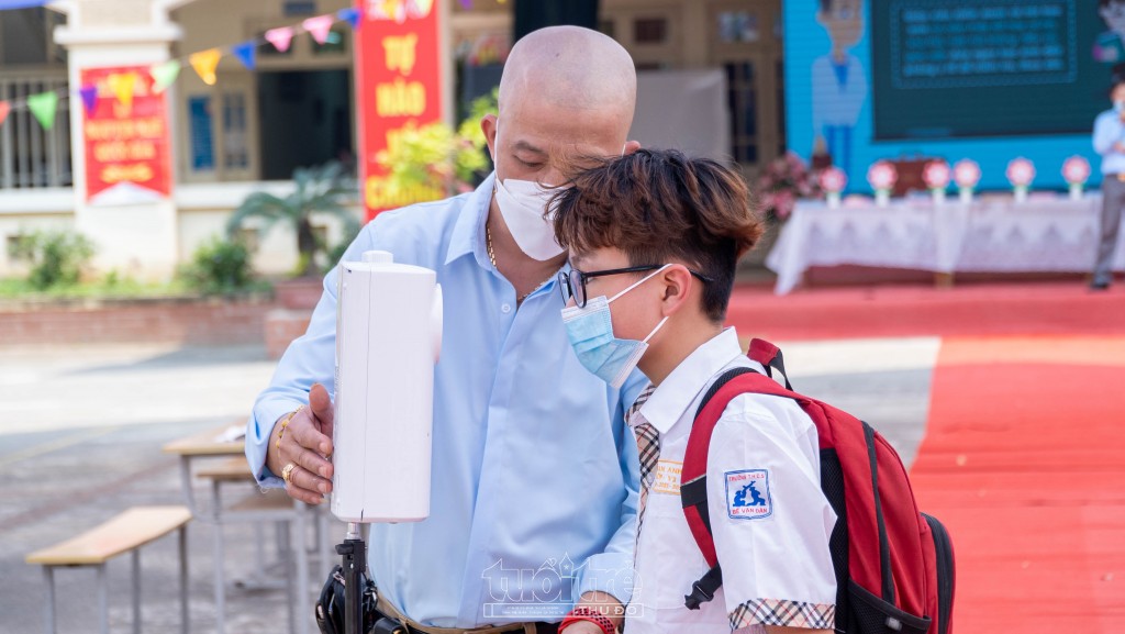 Anh Bùi Hải Quang (Ban Phụ huynh trường THCS Bế Văn Đàn) hỗ trợ học sinh đo thân nhiệt khi tới trường