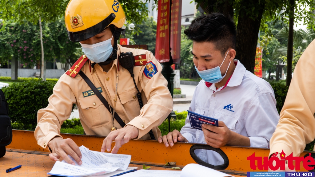 Thượng uý Chẩu Mạnh Cường (Đội CSGT Số 2, Phòng CSGT, Công an TP Hà Nội) lập biên bản xử phạt tài xế Nguyễn Văn Quang Linh lỗi vi phạm đỗ xe ở nơi có biển cấm dừng và cấm đỗ