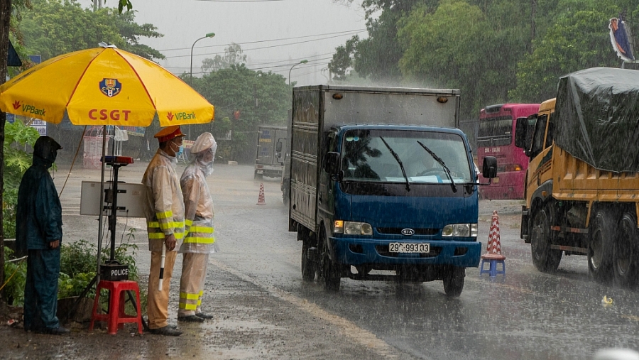 Lực lượng chức năng dầm mưa kiểm soát phương tiện nơi chốt kiểm soát ở cửa ngõ Thủ đô