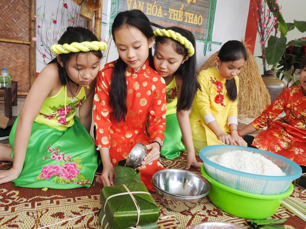 Trẻ con háo hức học gói bánh chưng ngày Tết (Ảnh minh họa)