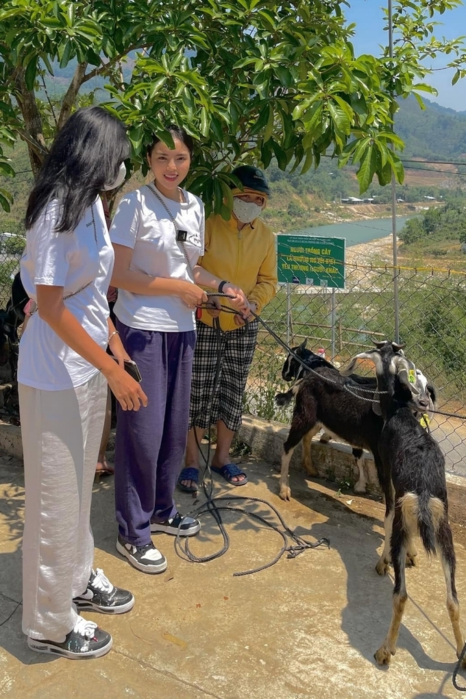 Minh Triệu (trái) và Kỳ Duyên trao một cặp dê giống cho một hộ dân