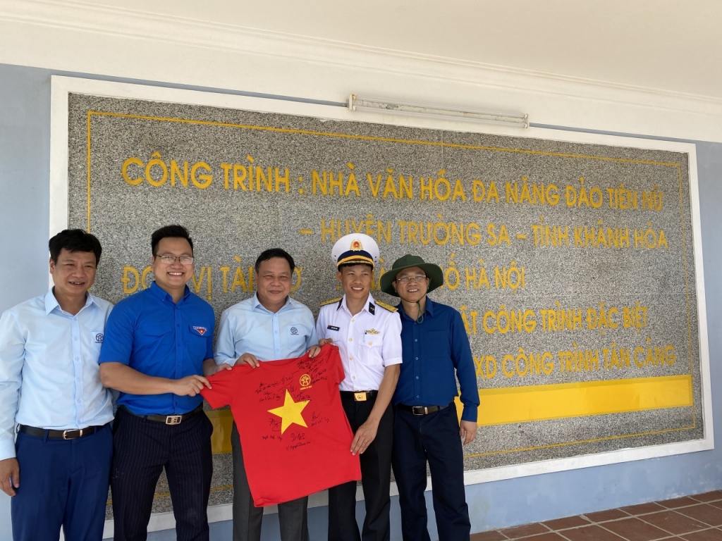 Đồng chí Nguyễn Văn Phong- Phó Bí thư Thành ủy Hà Nội (đứng giữa) và đồng chí Trần Quang Hưng với chiếc áo có chữ kí của chiến sĩ và Nhân dân nơi Đoàn công tác đến thăm và động viên