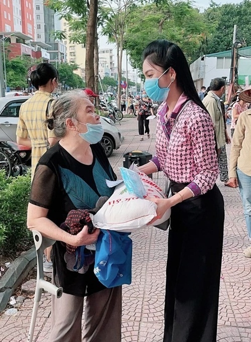 Kim Huyền Sâm trao quà cho một cụ bà chống nạng.