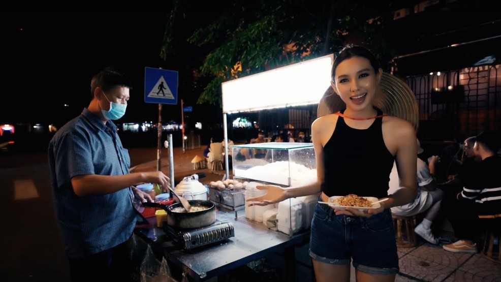 Thùy Tiên giới thiệu món bánh tráng trộn đến BTC Miss Grand International