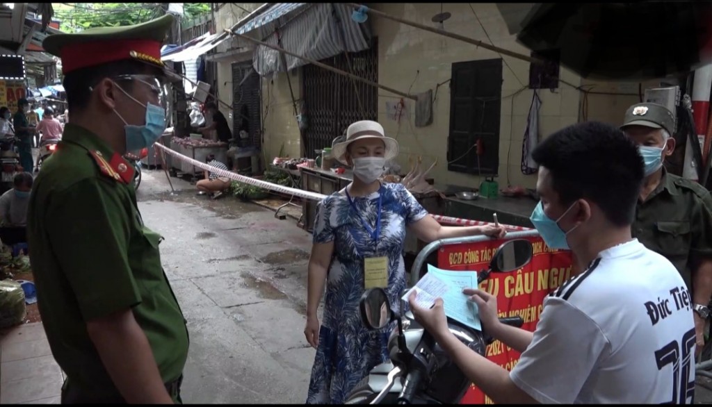 Lực lượng chức năng tại phường Thanh Xuân Nam (Thanh Xuân, HN) kiểm tra phiếu đi chợ của người dân