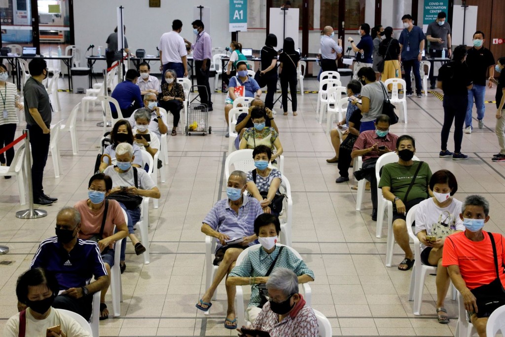 Những người trên 70 tuổi được theo dõi phản ứng sau khi tiêm vắc-xin COVID-19 một trung tâm tiêm chủng ở Singapore (Ảnh Reuters)