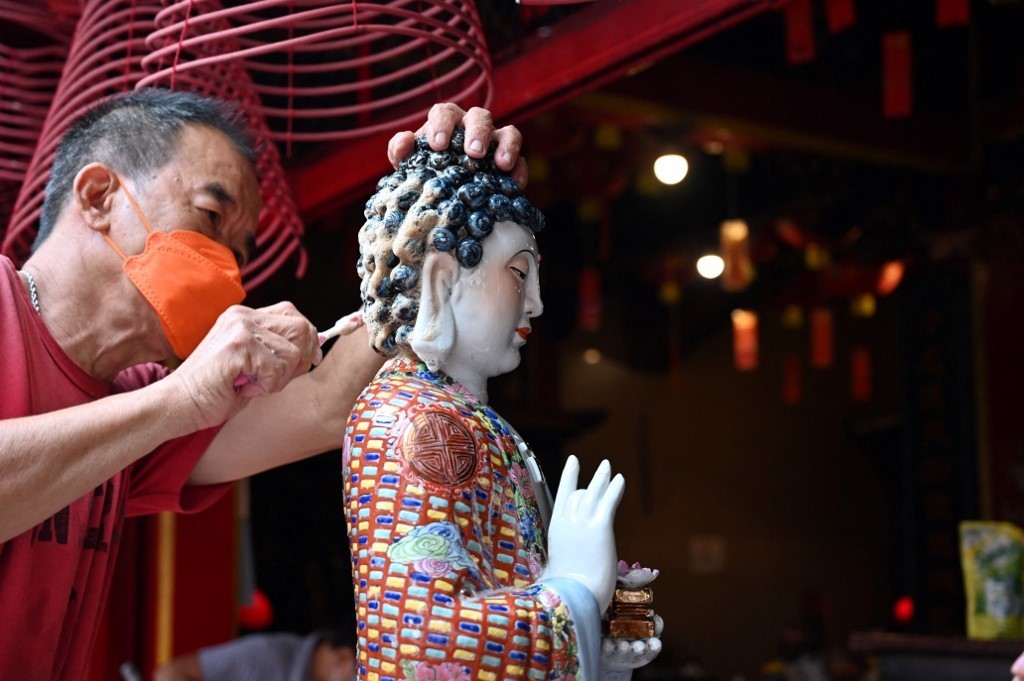 Một người đàn ông làm sạch tượng Phật trong ngôi chùa ở Jakarta, Indonesia, ngày 26/1.