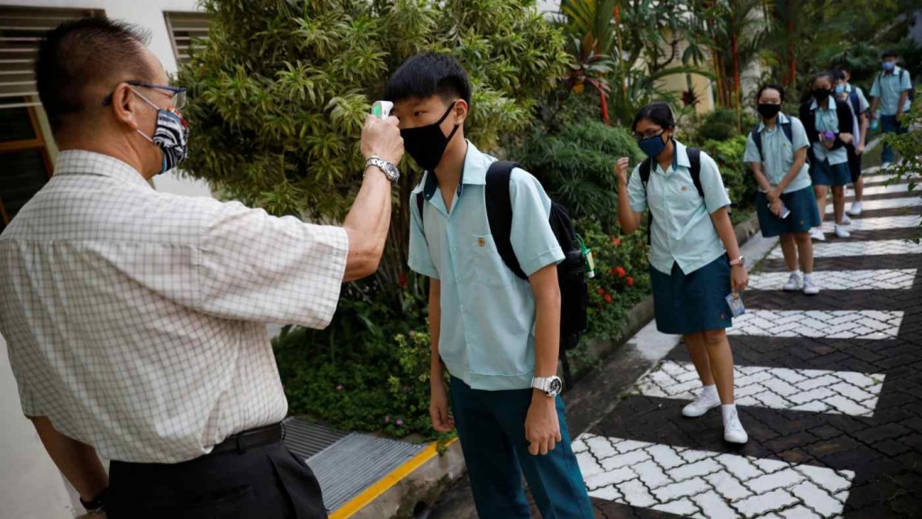 Học sinh tại Singapore được đo thân nhiệt trước khi vào lớp (Ảnh: Reuters)