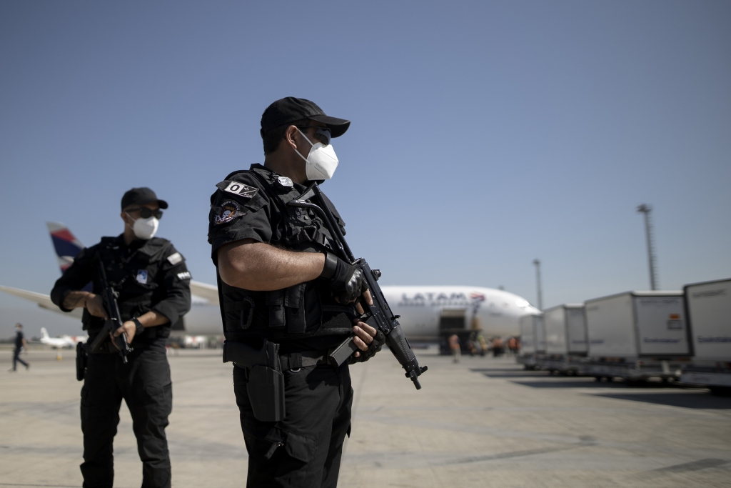Nhân viên an ninh có vũ trang đứng gác trong quá trình giao vắc-xin Sinovac tại sân bay Santiago ở Chile (Ảnh: Getty)
